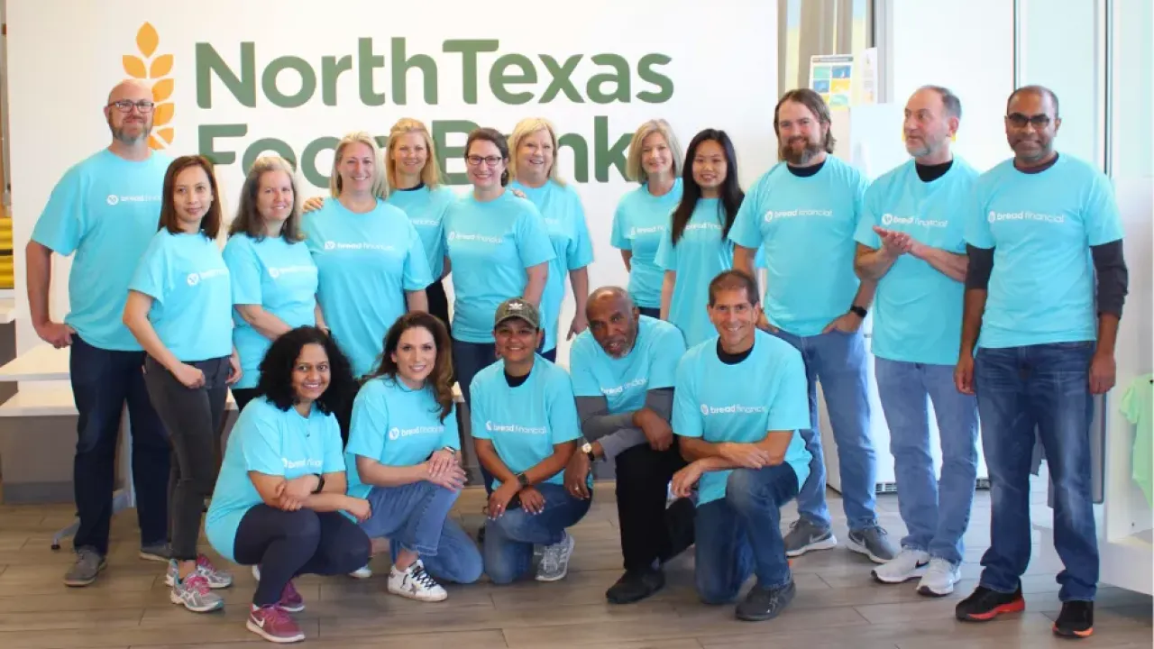 Calvin and a group of others in matching blue "Bread Financial" tshirts, posing in front of a wall with "North Texas Food Bank" on it.