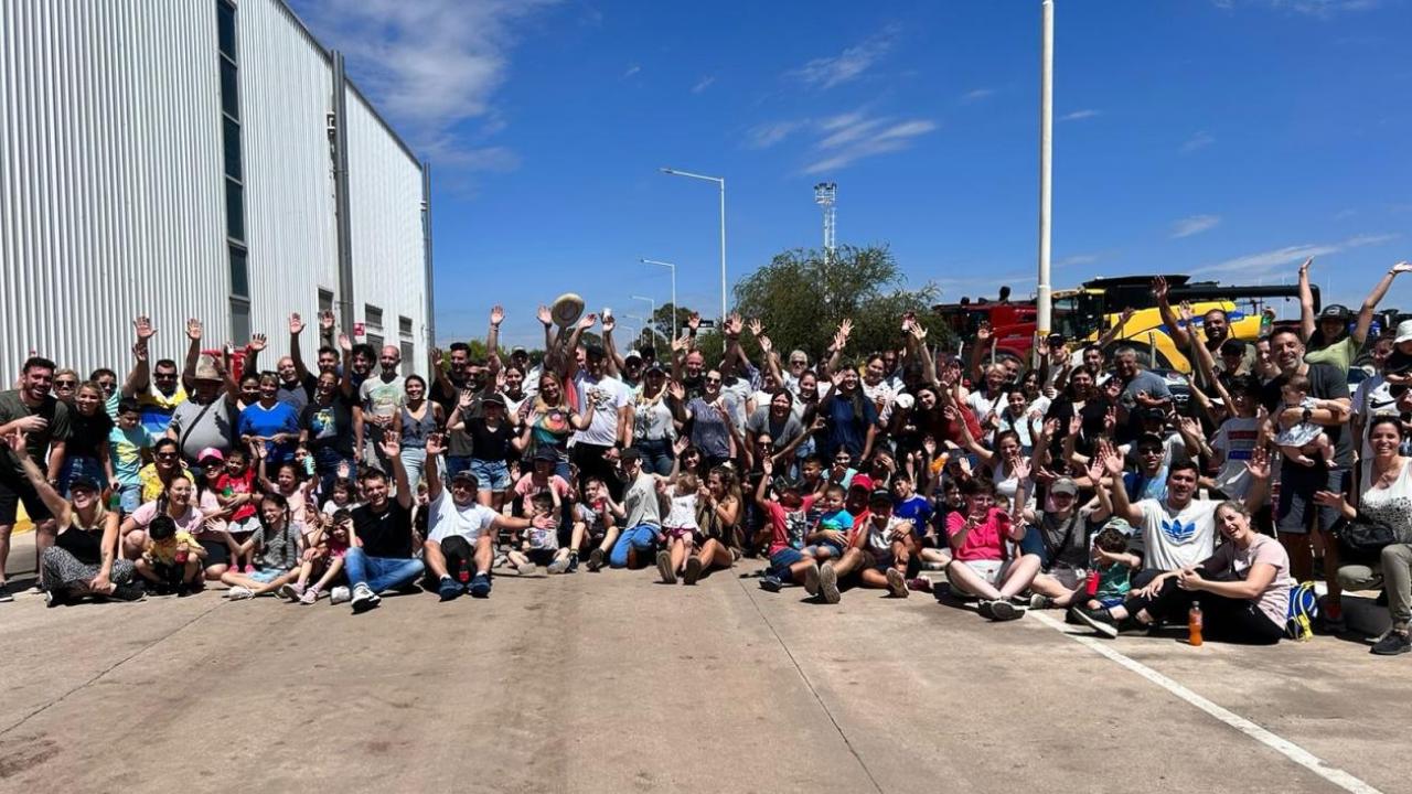 A large group posed outside, some with raised hands