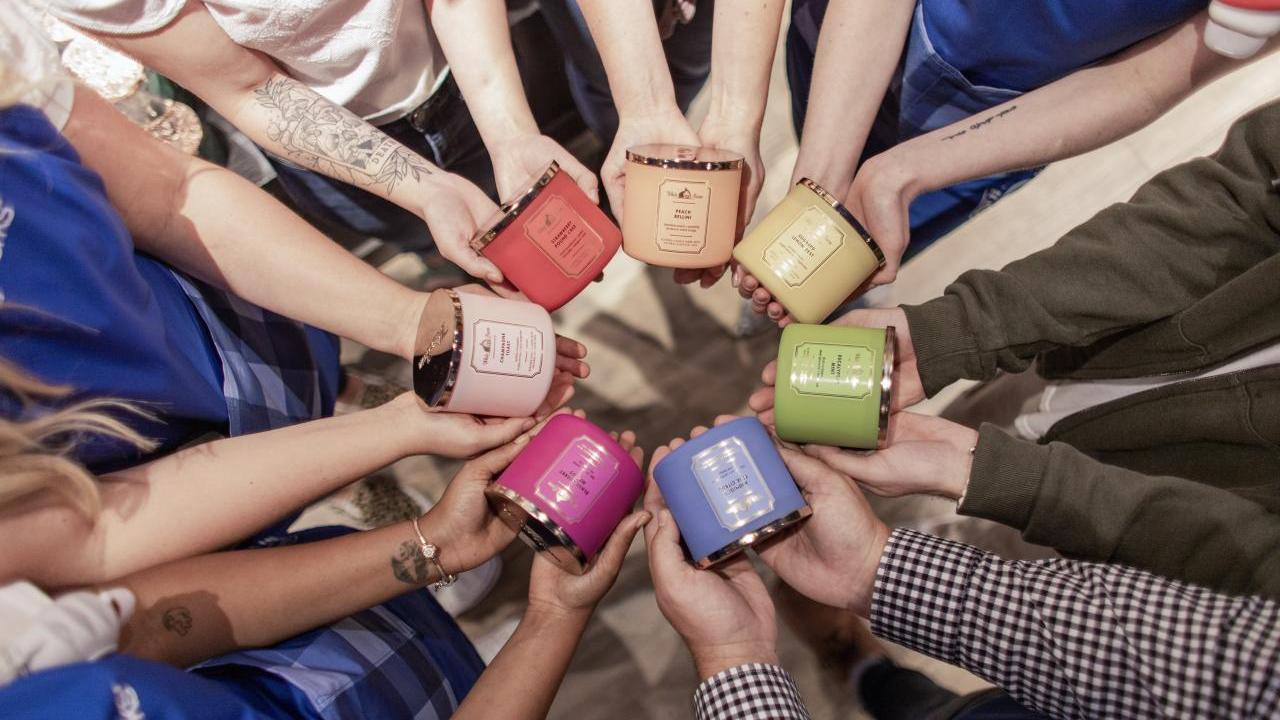 Hands holding candles in different colors