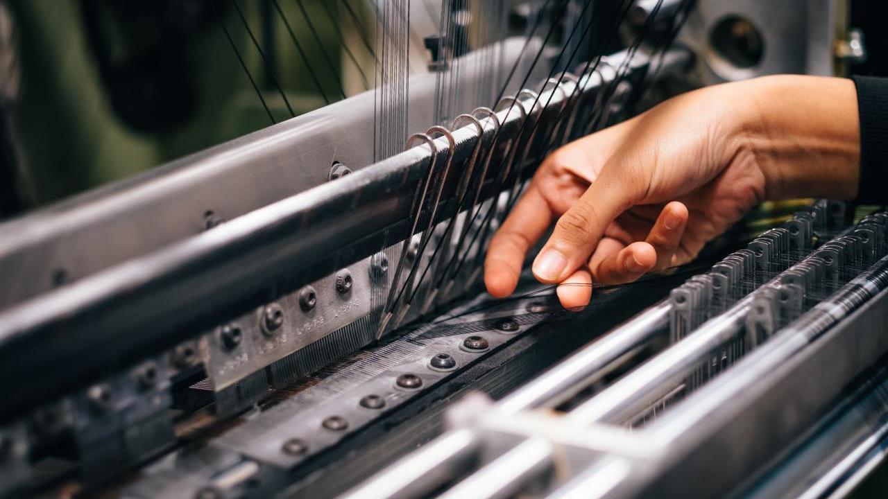Hands working on knitting machine