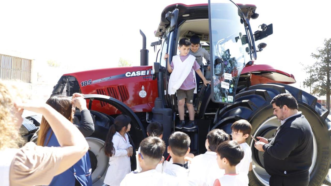 Children looking at and climbing into red tractor