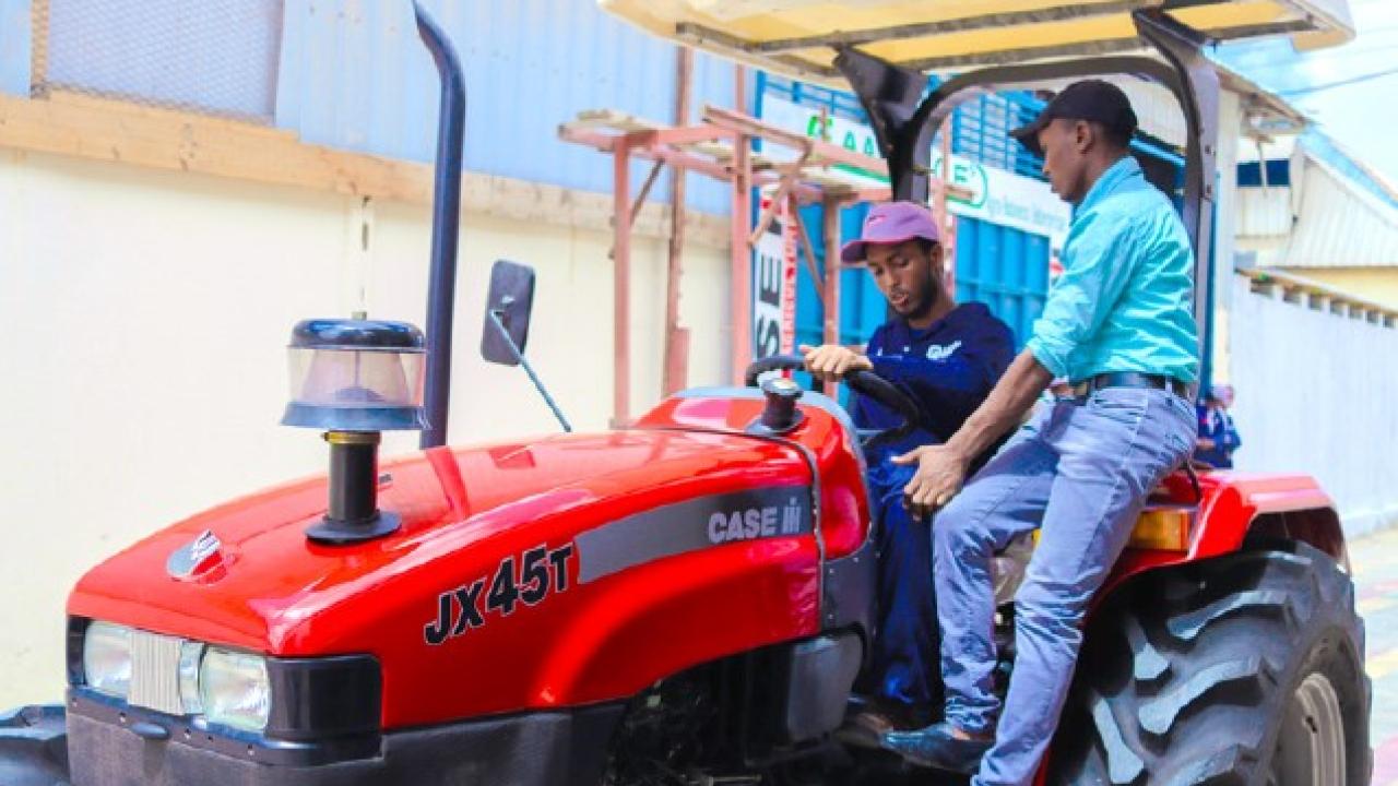 Two people sitting on tractor, talking