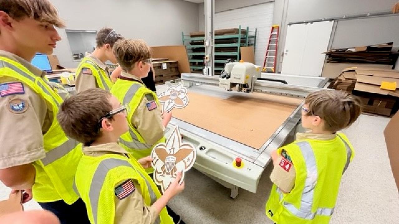 Children wearing hi-vis vests inside a manufacturing facility 