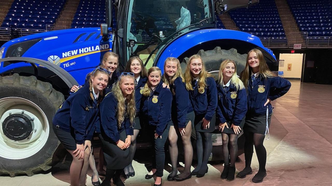 group of young women in front of New Holland tractor