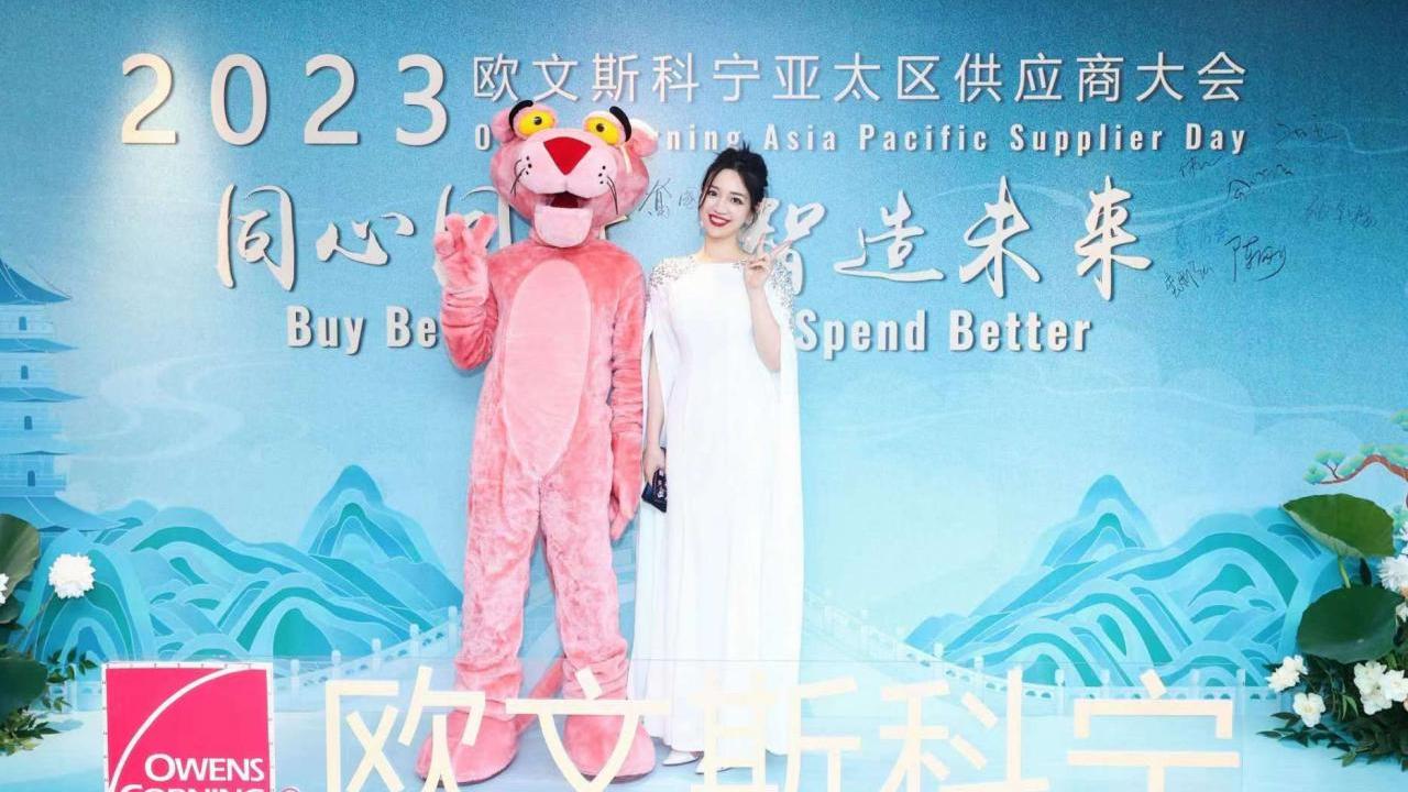 Cheria Liu next to the owens corning mascot.