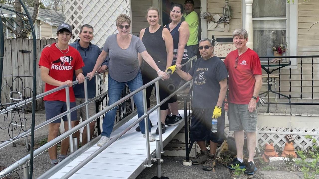 Frank and Shelby shown with Habitat for Humanity volunteers in front of the new ramp at their home.