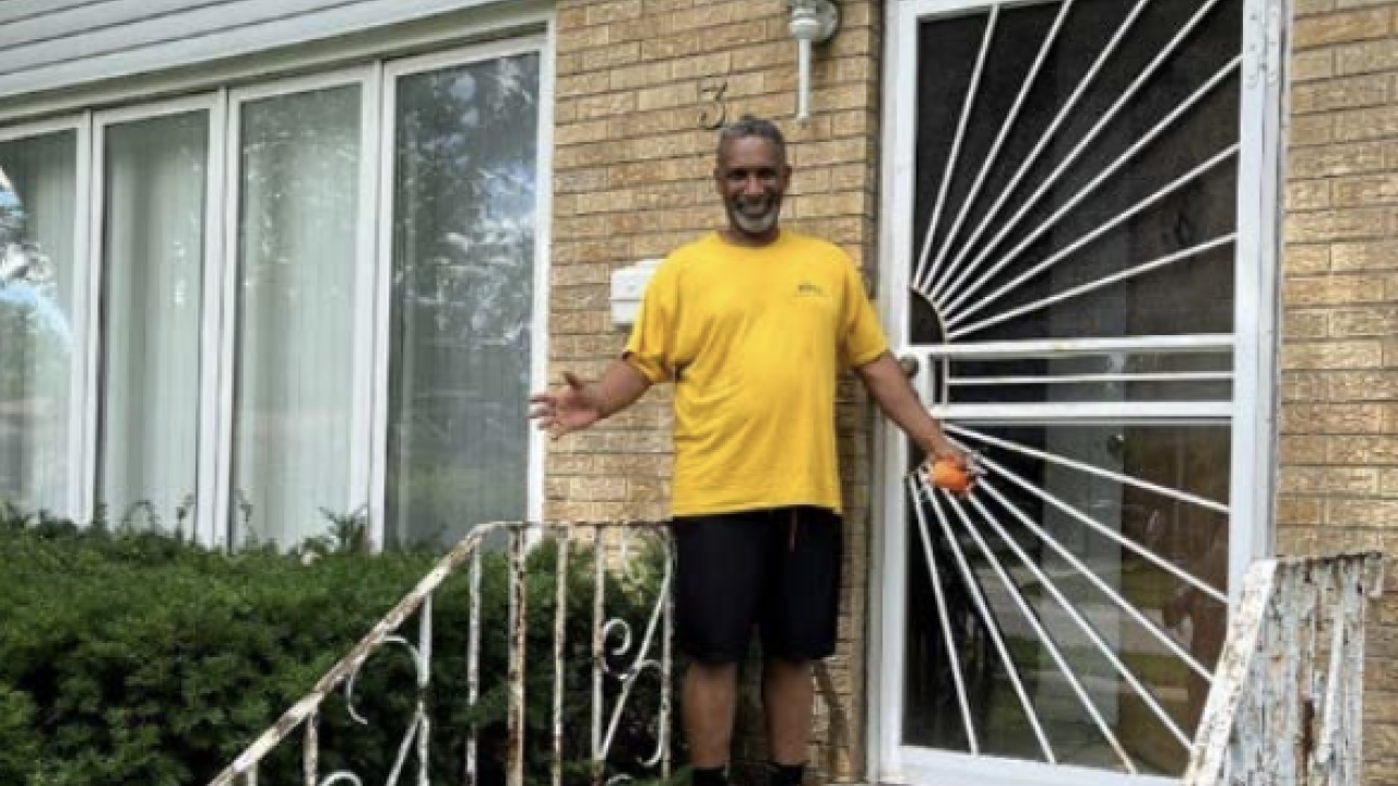Derek shown in front of his family home.