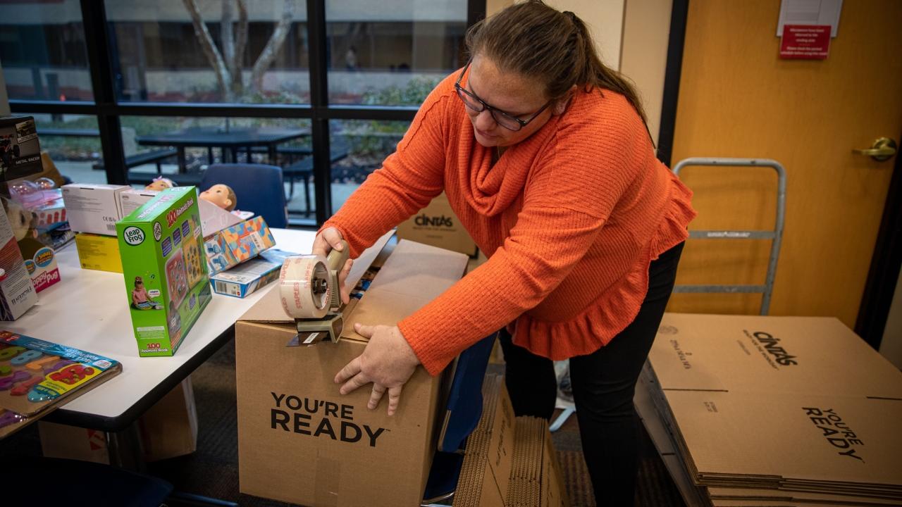 woman taping up a box