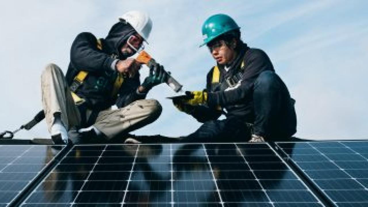 2 people installing a solar panel