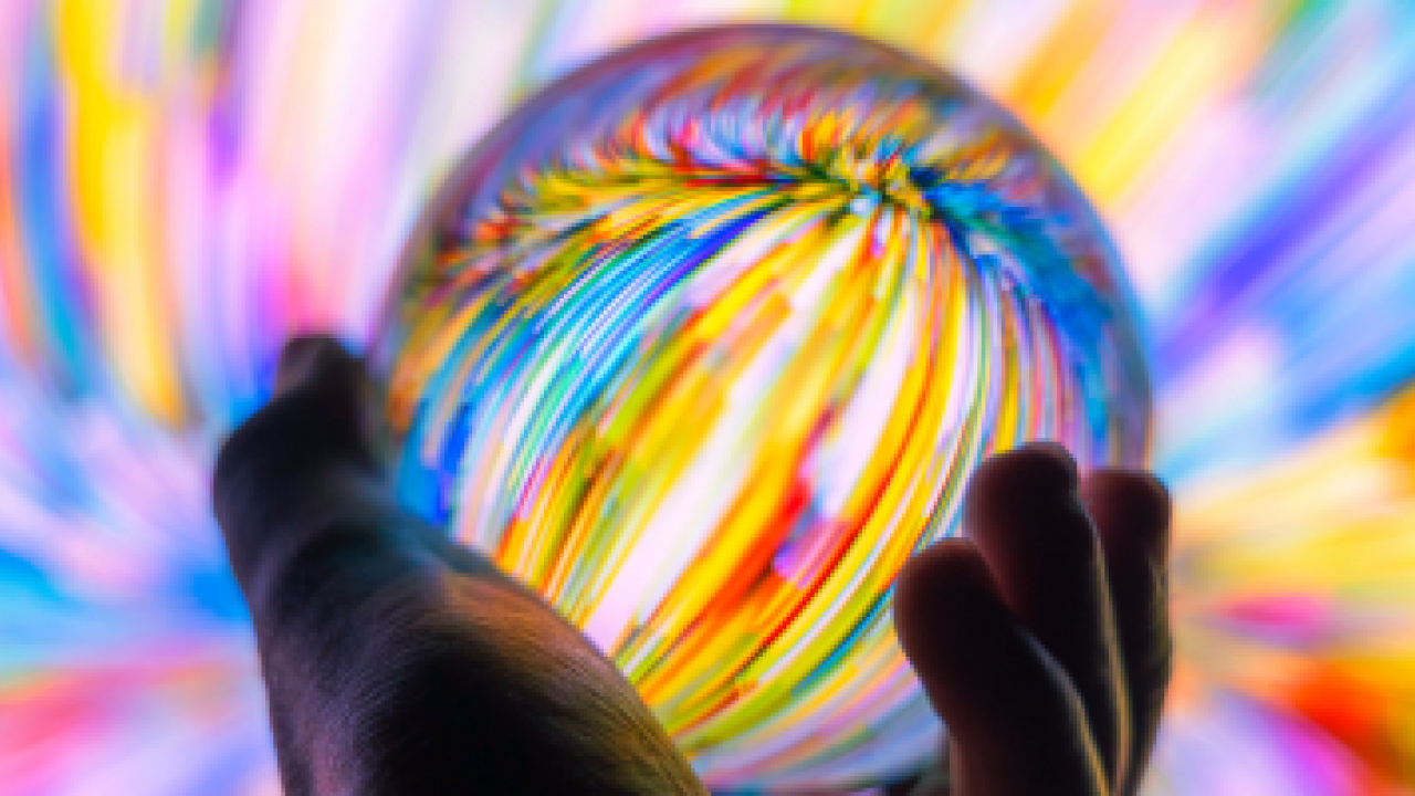 A person holding a colourful glass ball 