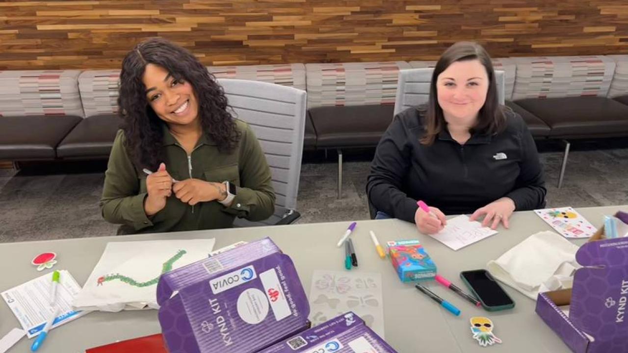 2 people at a table making cards