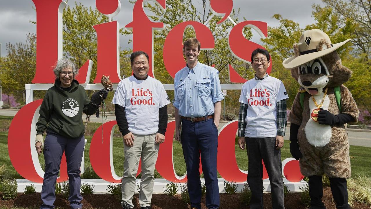 Group photo in front of "Life's Good" sign