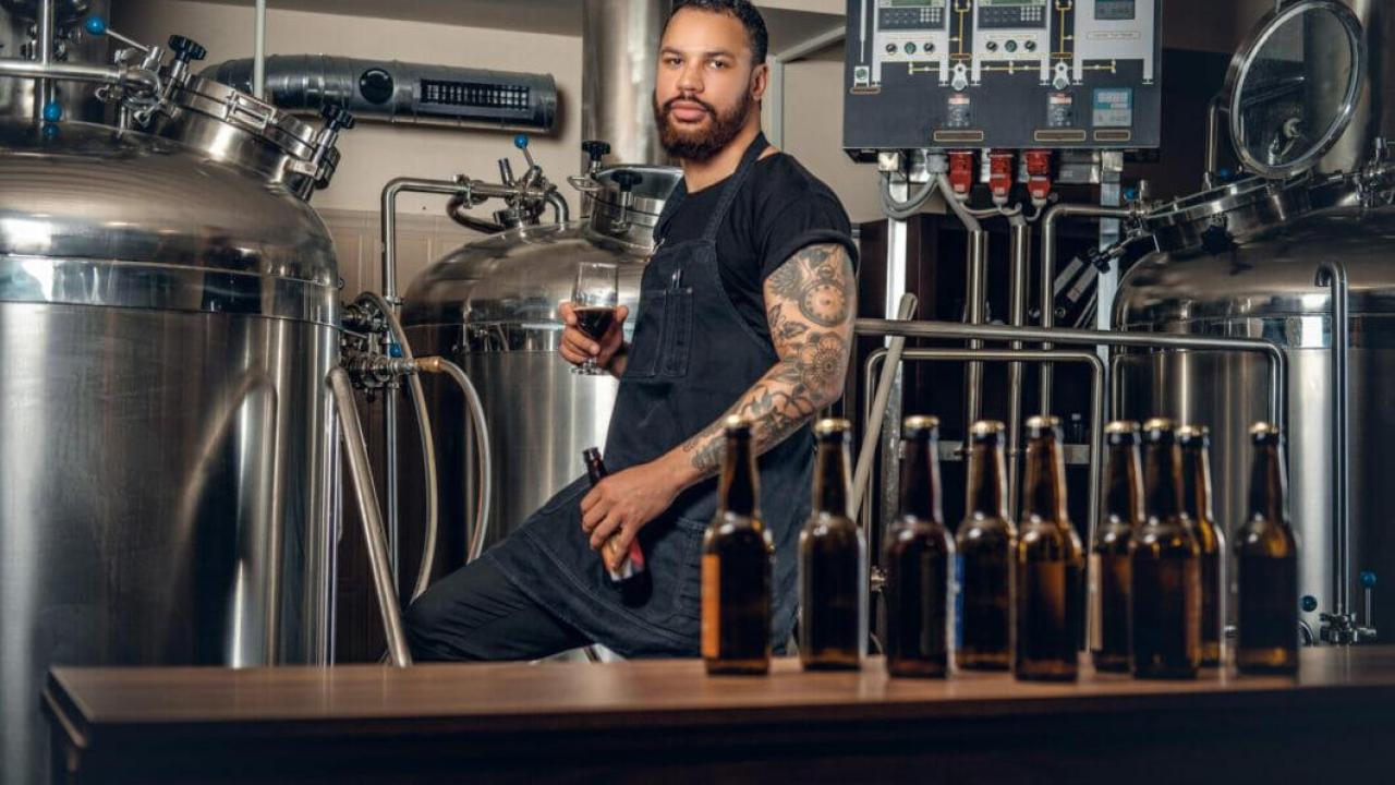 Photo of bartender behind a craft beer bar, looking into the camera