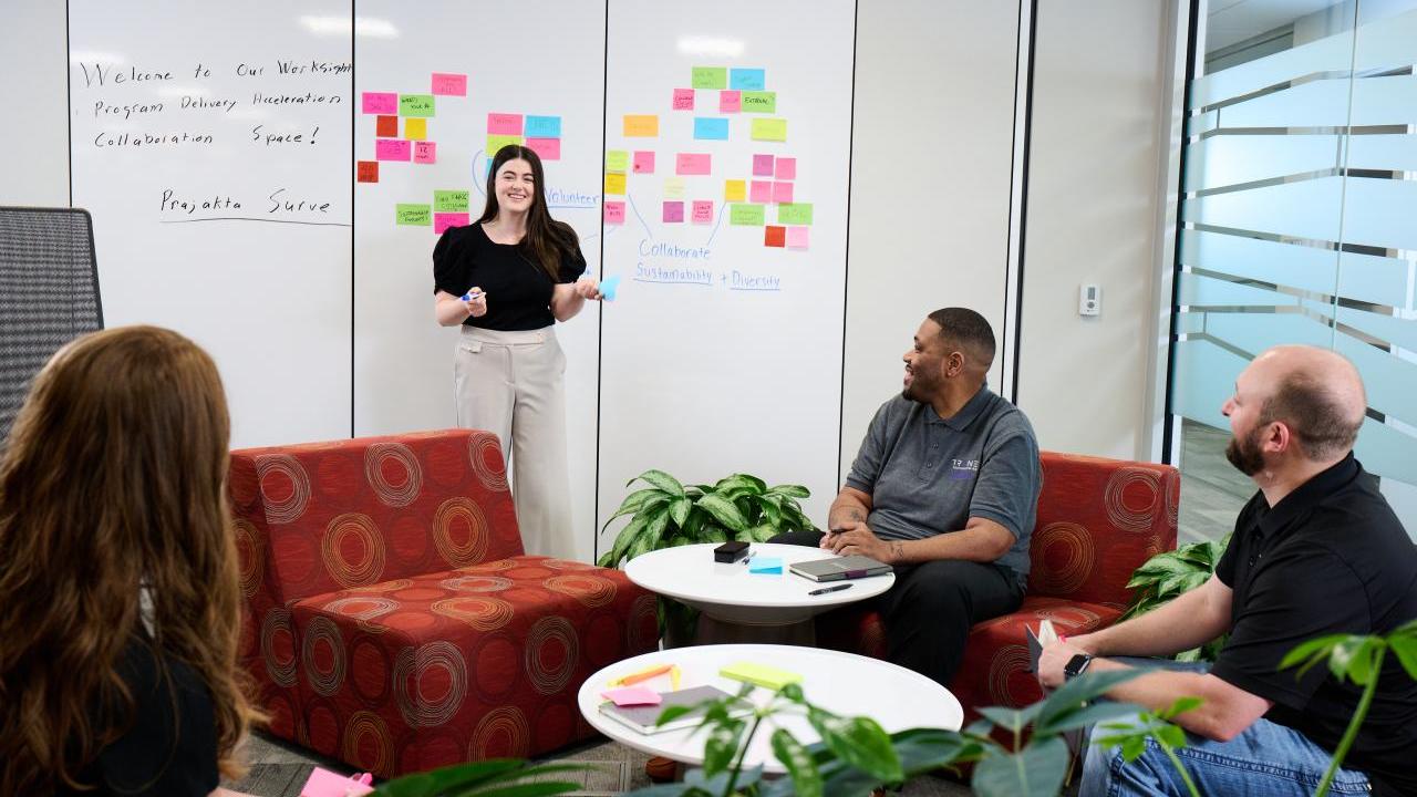 People talking together in front of a whiteboard