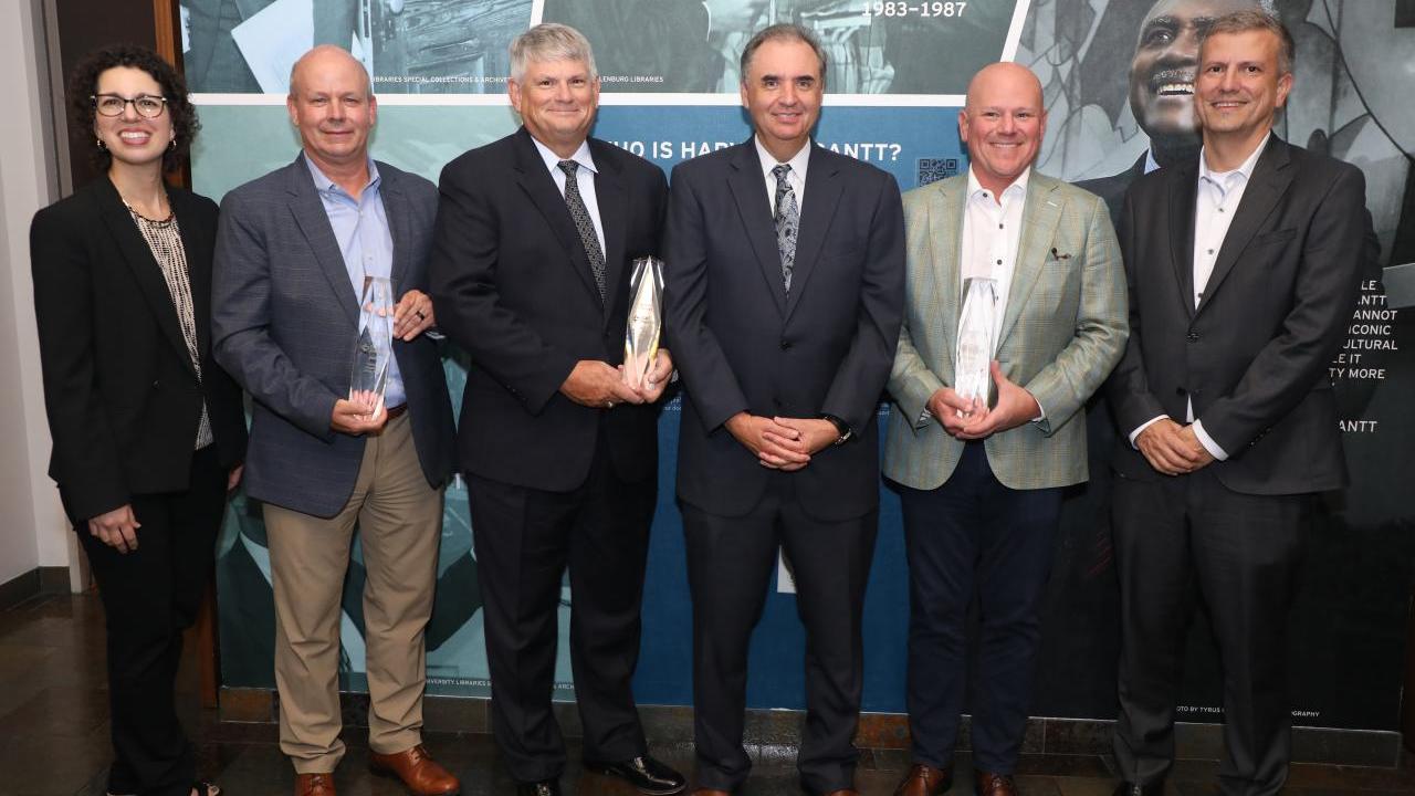 6 people pose with award