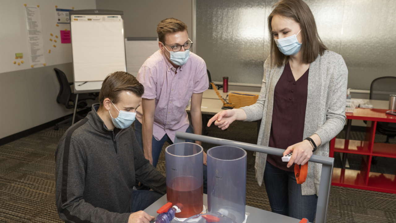 The model uses dyed water to simulate a pipeline cut and fill different tanks from a manifold.