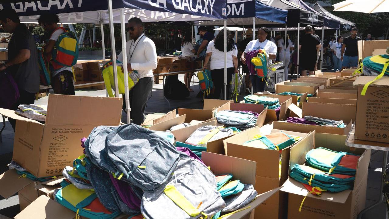 Employees from AEG, LA Galaxy and LA Kings help pack backpacks for under-resourced students at their school supplies drive.