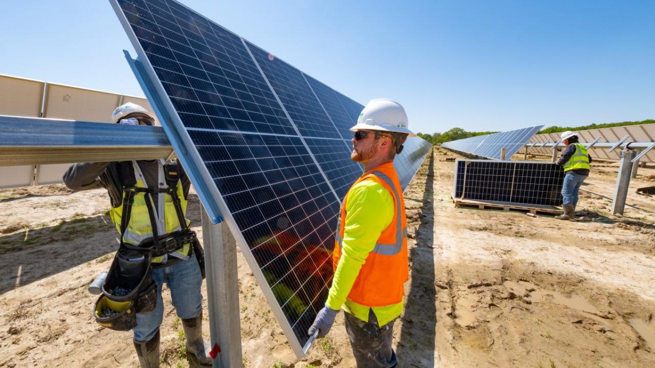 two men working on solar panels