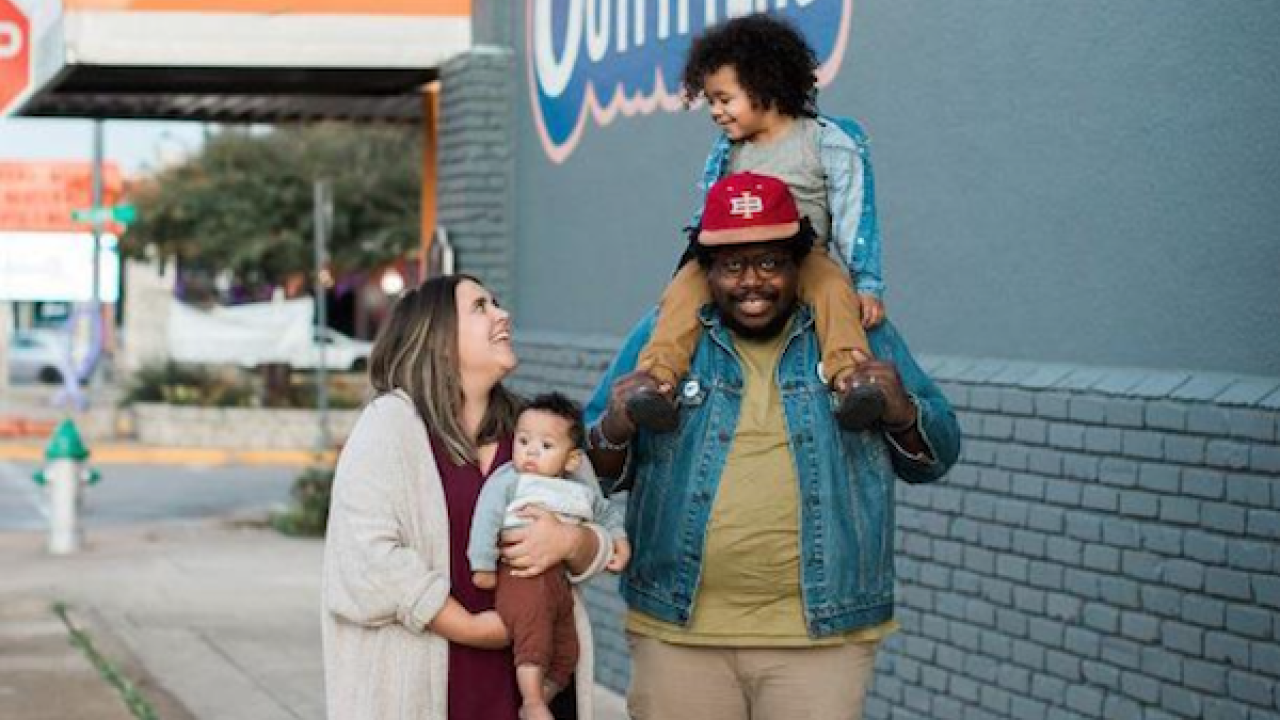 Jahmicah and Heather Dawes with their two children in front of Slim Pickins Outfitters.