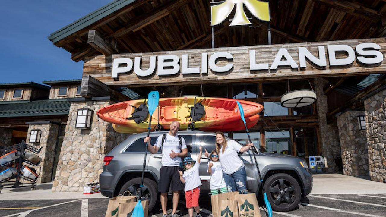 Jax Ramirez and his family pictured in front of Public Lands. A kayak is loaded on top of the family car.