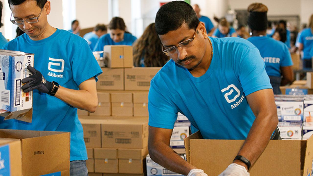 people in aqua abbott t-shirts packing boxes