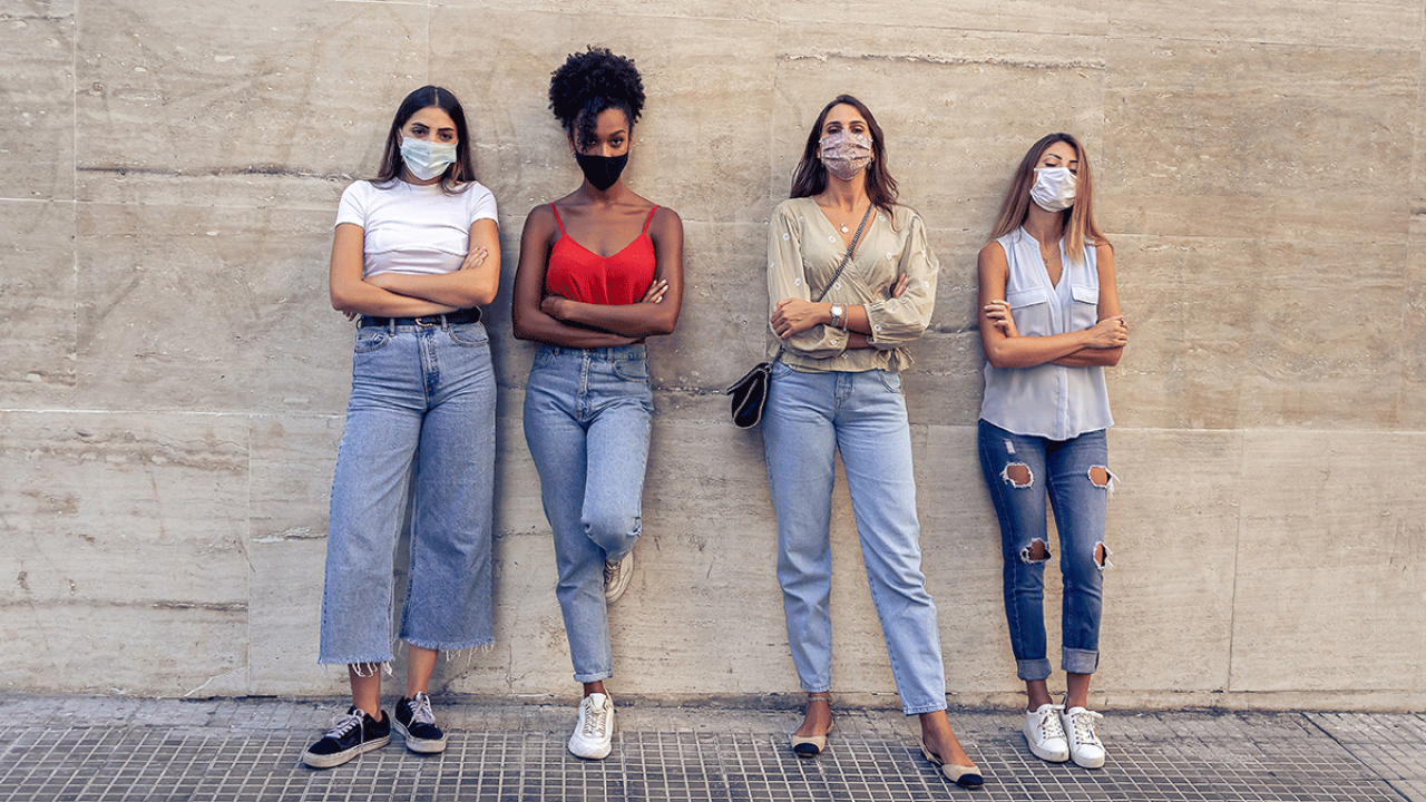 four women standing against a wall