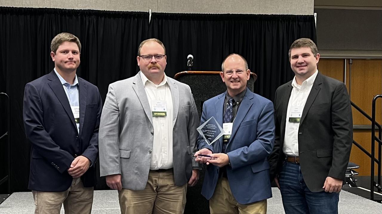 4 employees holding award