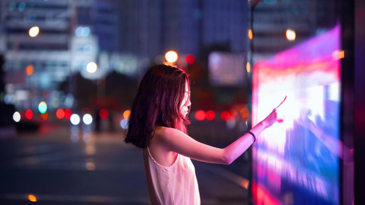 person touching large screen