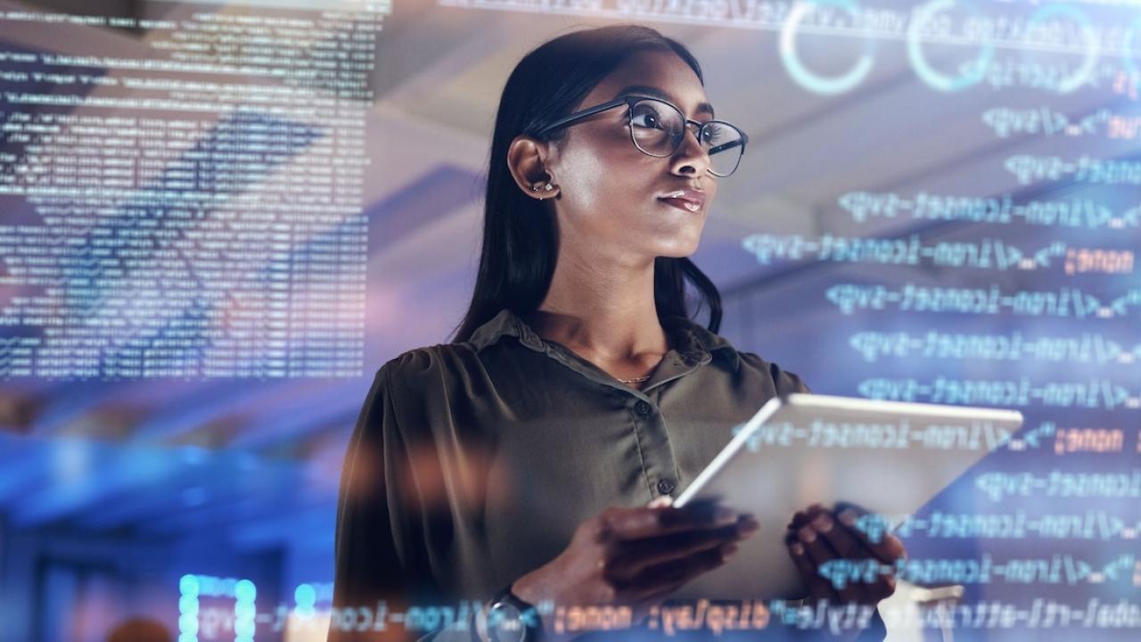 A person holding a tablet device looking at a digital screen 
