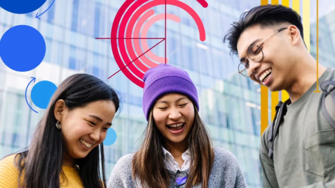 Three Asian people looking at their phones and smiling.