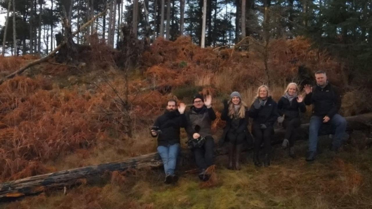 a group of people in the woods waving at the camera