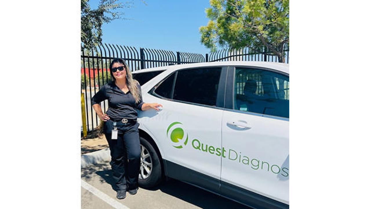 Esmeralda Bonilla standing next to a Quest vehicle