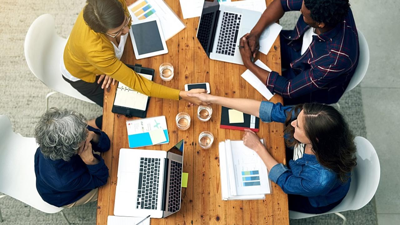 group of people working on laptops, viewed from above