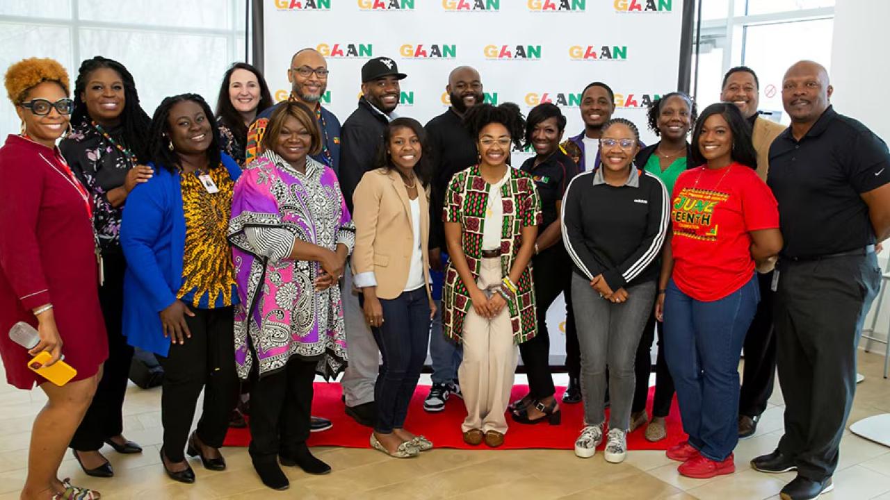 A large group photo taken in front of a GAAN back drop 
