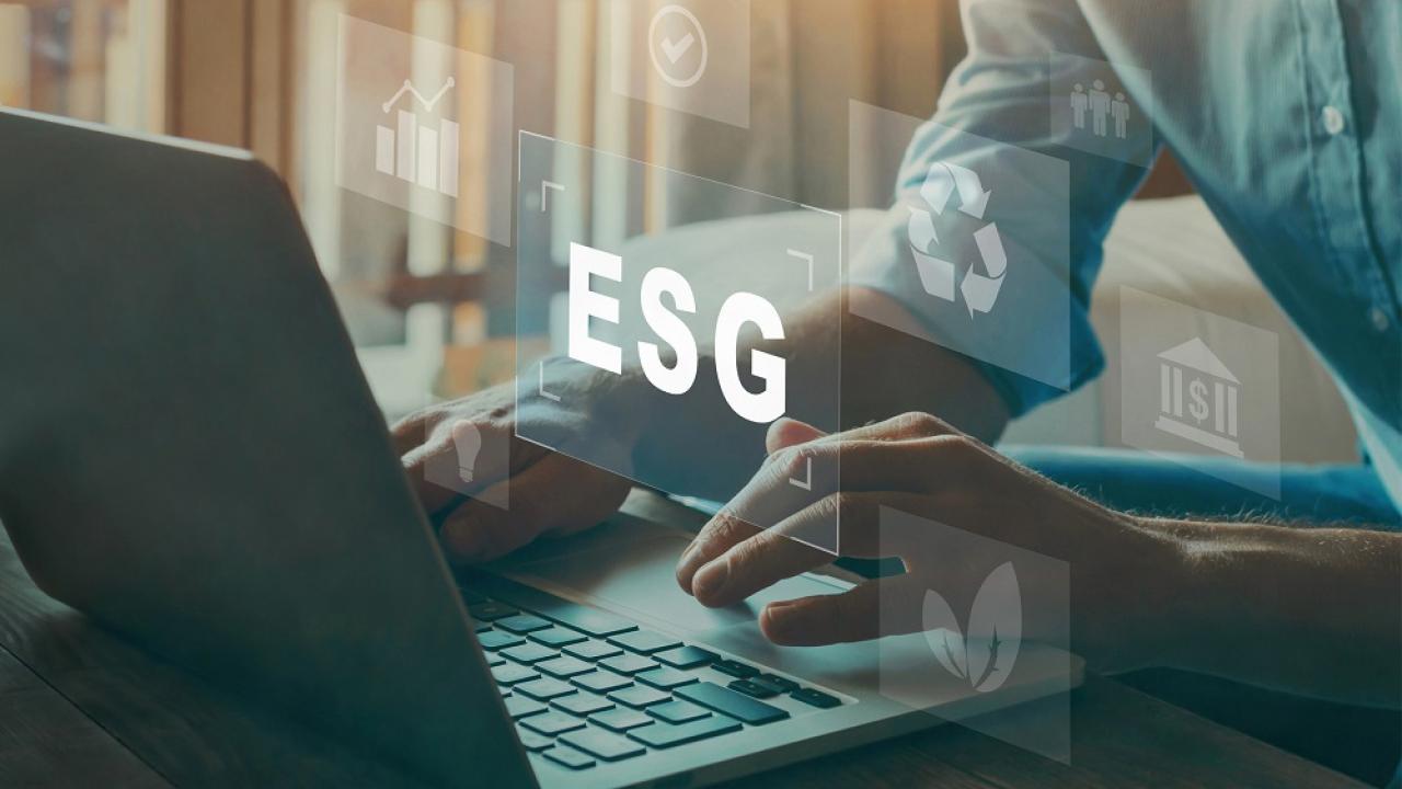 Person typing on laptop with ESG floating above