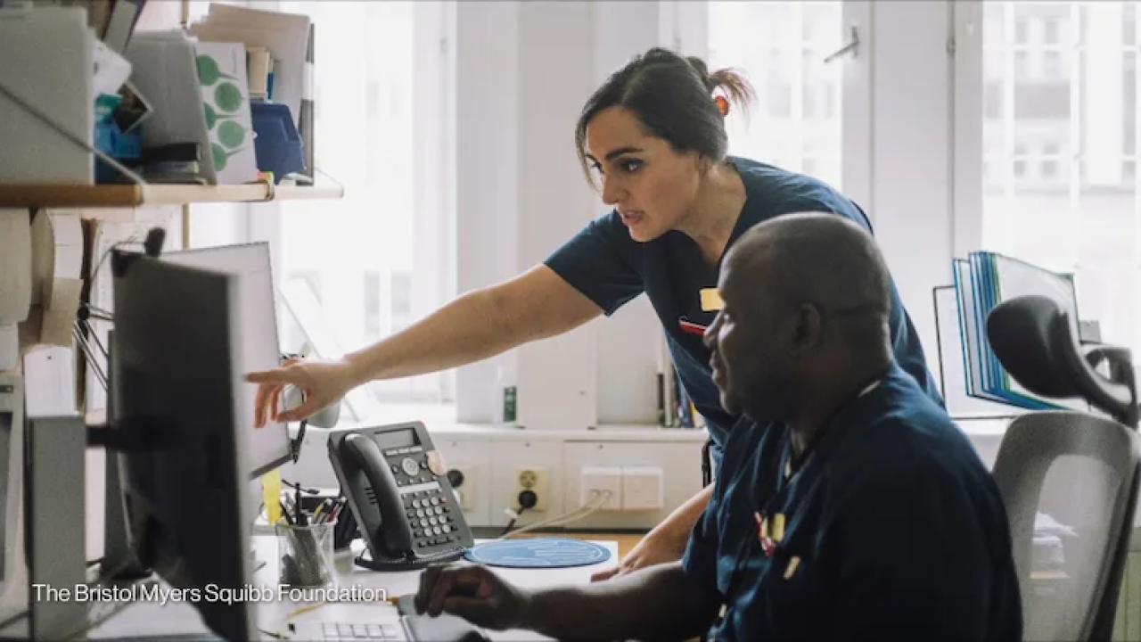 Health care workers consult their notes in a clinic. Photo by: The Bristol Myers Squibb Foundation