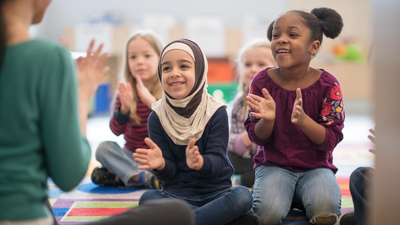 children sitting down clapping their hands