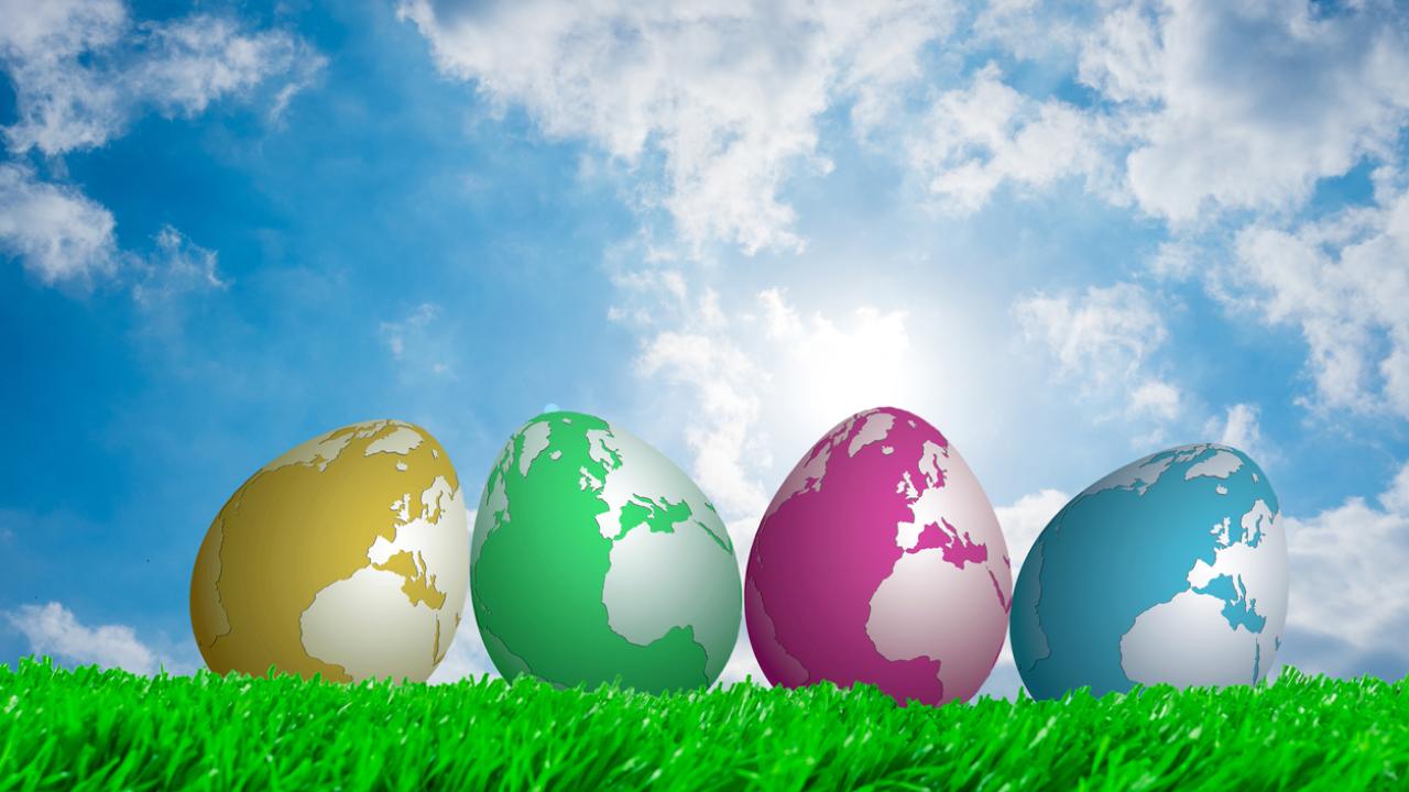 eggs with globe pattern on grass with blue sky background