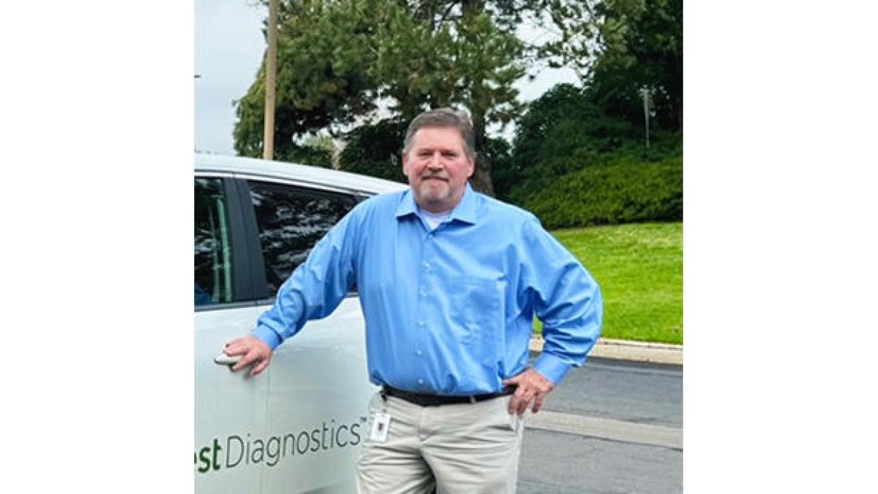 Eddy Hurst stood next to a white car