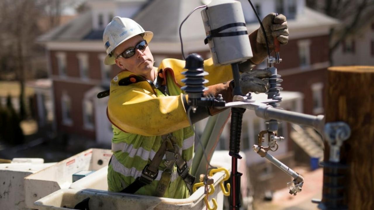 Lineworker maintaining an overhead electricity line