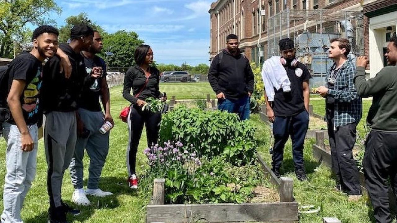 Several people standing around garden beds at Ellen DeGeneres urban farm