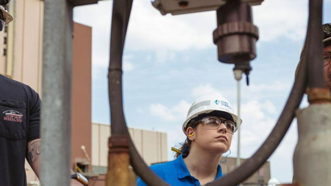 Emily Jones and two others inspecting equipment.