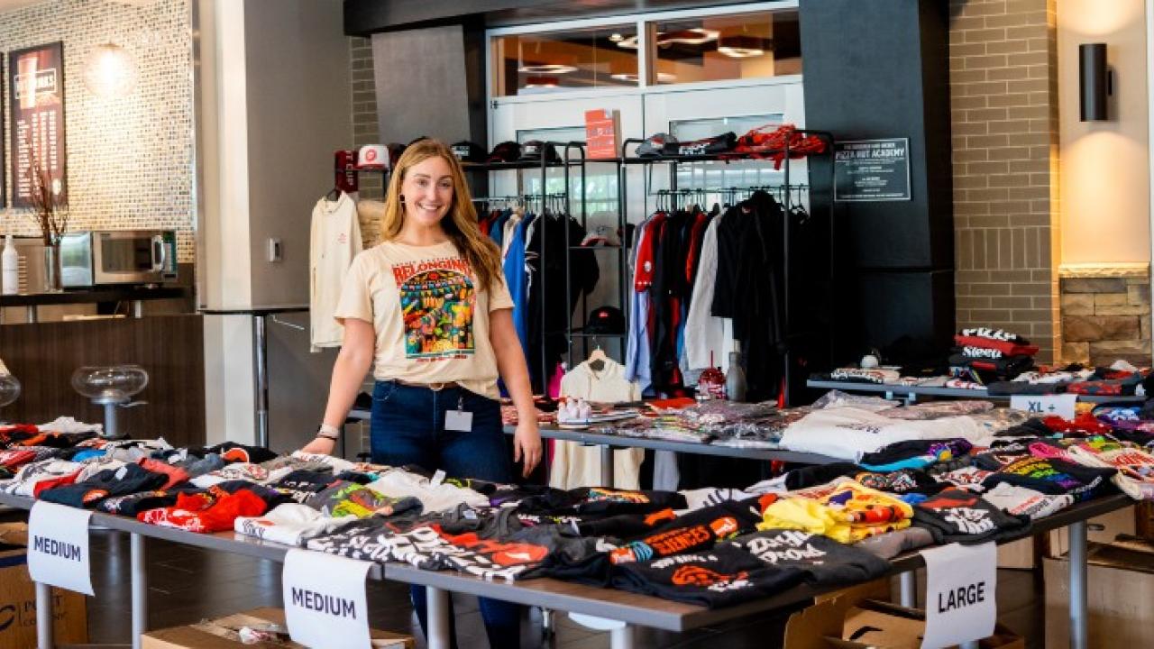 Emily standing with different clothing items
