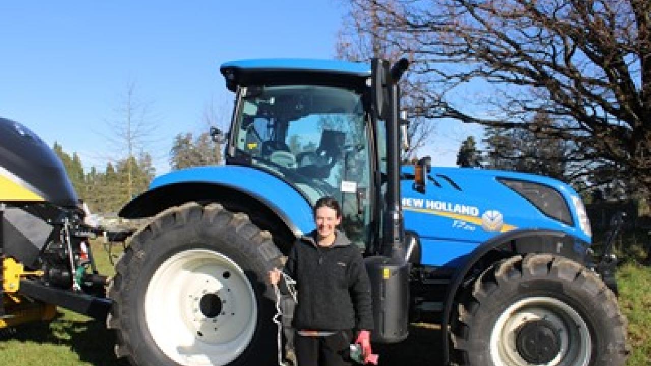 Emma Poole in front of a New Holland tractor.