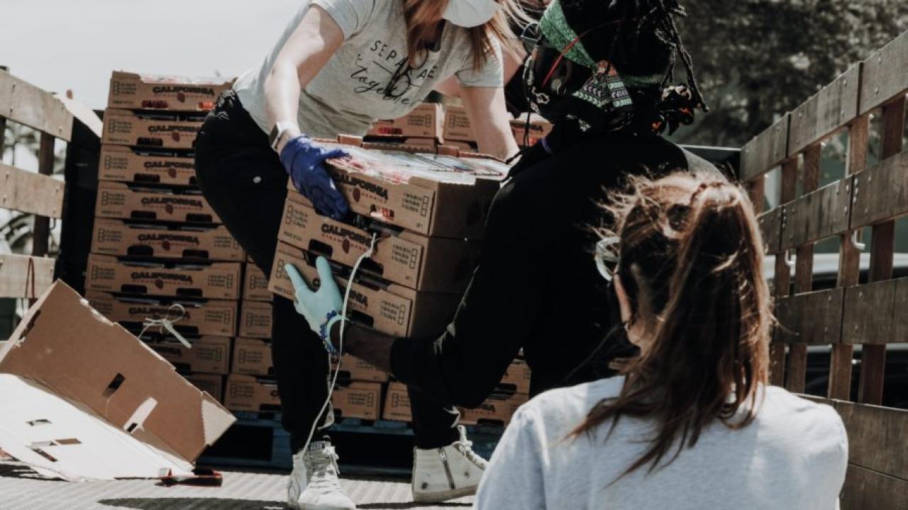 volunteer passing boxes off a truck 
