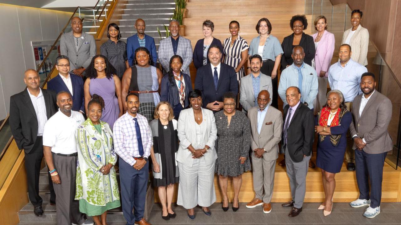 A large group photo of people stood on a stair case 