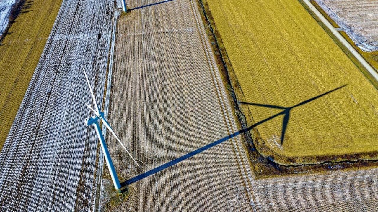 Aerial view of farms with wind turbines and a country road