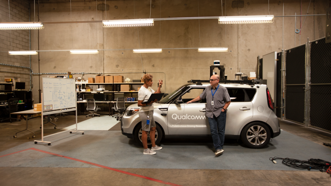 Engineers testing in auto lab in front of car