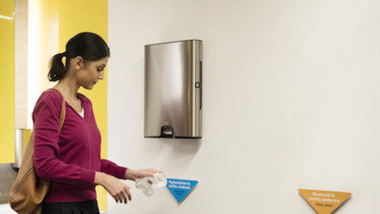 Woman disposing of a hand towel.