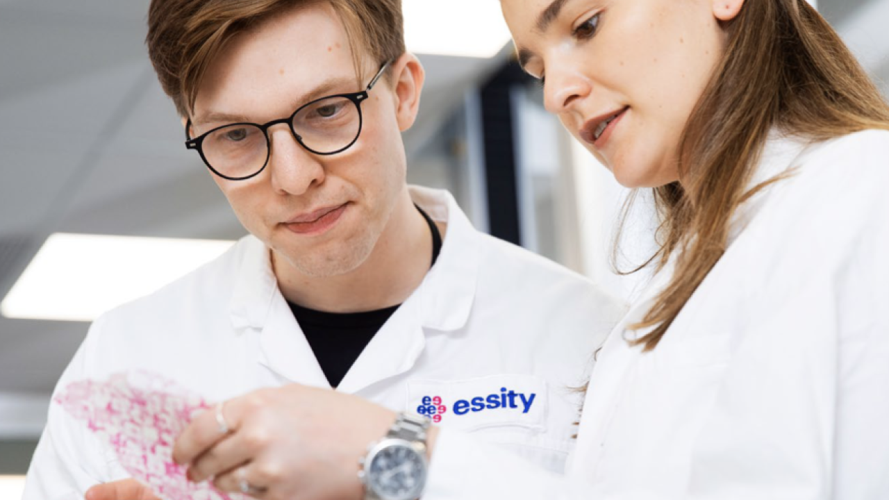 A female and a male technician are looking at a report.